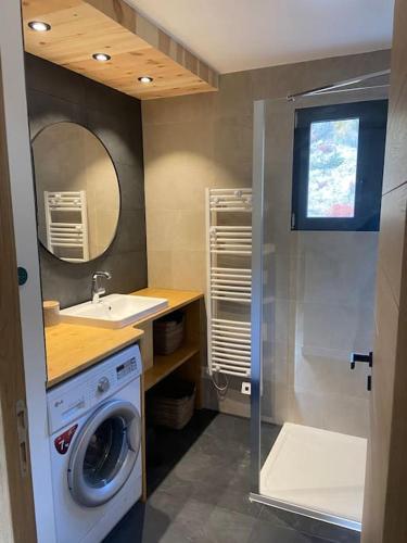 une salle de bain avec une machine à laver et un lavabo dans l'établissement 3 chambres, calme, vue imprenable, refait à neuf, au Monêtier-les-Bains