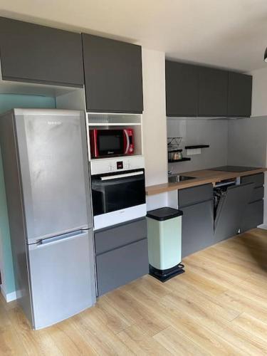 une cuisine avec un réfrigérateur et un micro-ondes dans l'établissement 3 chambres, calme, vue imprenable, refait à neuf, au Monêtier-les-Bains