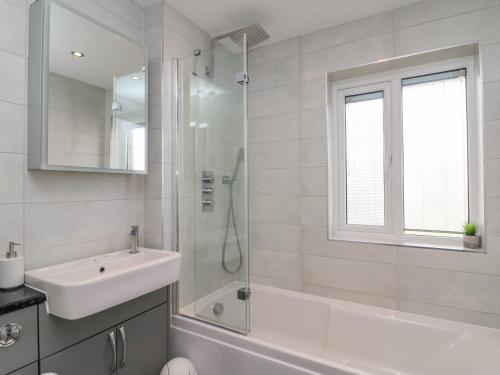 a white bathroom with a sink and a shower at Home Waters in Weymouth