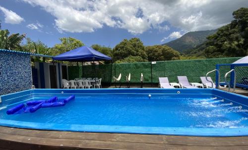 a large pool with chairs and a table at Hostal Paraiso Minca in Minca