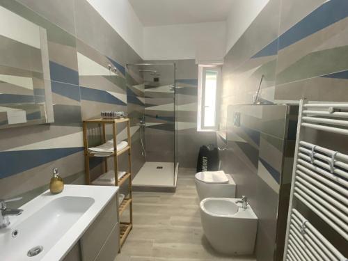 a bathroom with a sink and a toilet at Casa vacanze Ķ-HOME in Salerno