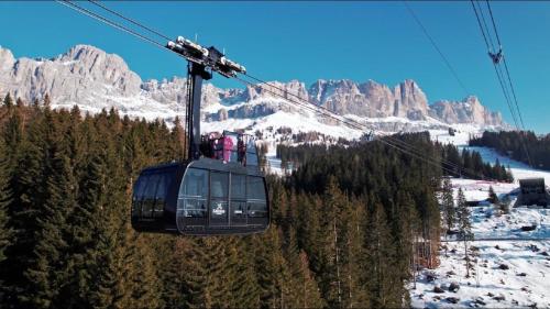 a group of people riding a ski lift in the mountains at Haus Helga in Tires