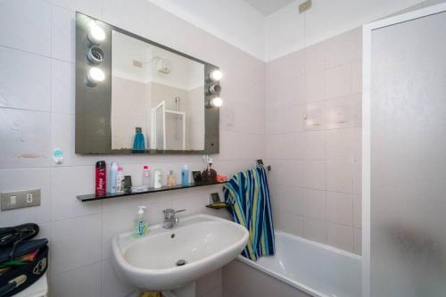 a white bathroom with a sink and a mirror at Carla House in Celle Ligure