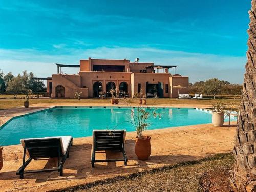 una casa con piscina di fronte a un edificio di Villa d'Orient a Marrakech