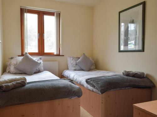 2 camas en una habitación con espejo y ventana en Sovereign House, en Milford Haven