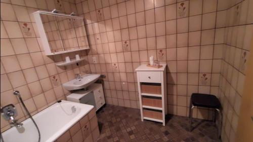 ein Badezimmer mit einem Waschbecken, einer Badewanne und einem Waschbecken in der Unterkunft Haus Amalie in Bad Hindelang