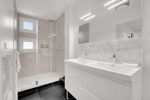 une salle de bain blanche avec un lavabo et une douche dans l'établissement Le Synopsis - Joli T3 avec garage, à Toulouse