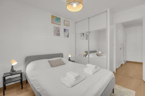 - une chambre blanche avec un lit blanc et un miroir dans l'établissement Le Synopsis - Joli T3 avec garage, à Toulouse