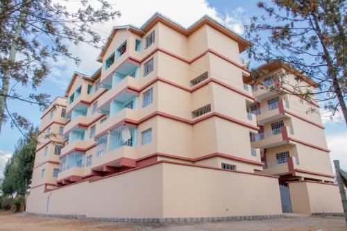 a tall building with balconies on it at Trice Homes One Bedroom Condo at Lavender Apartment in Nanyuki