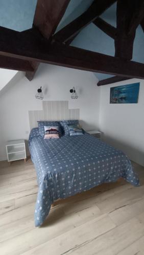 een slaapkamer met een bed met een blauw dekbed bij Maison T4 a 6 minutes à pieds de Sarlat in Sarlat-la-Canéda