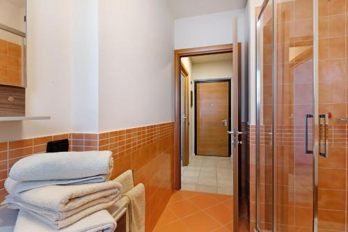 a bathroom with a shower and a pile of towels at Maison del Sasso Lago Maggiore in Leggiuno