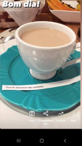 a cup of coffee on a plate on a table at Refúgio da Montanha in Urubici