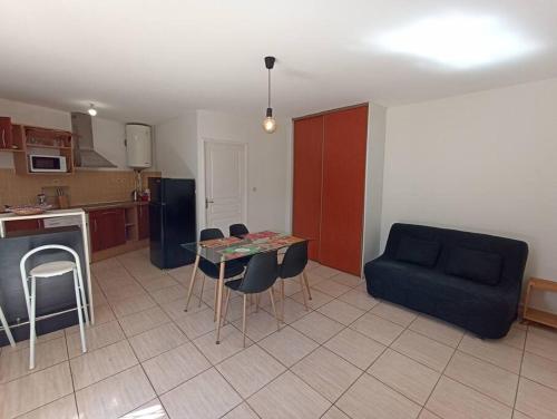 ein Wohnzimmer mit einem Tisch und einem blauen Sofa in der Unterkunft Spacieux studio tout équipé in Le Tampon