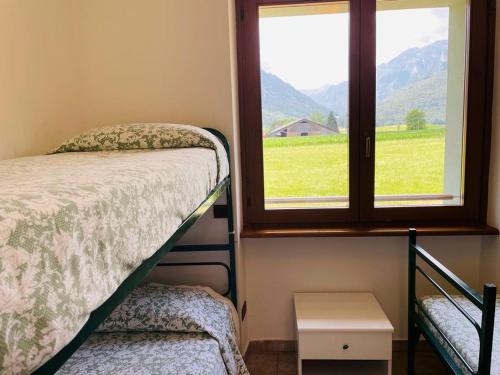 1 dormitorio con cama y ventana con vistas en Foresteria Miramonti affittacamere, en Fiavè