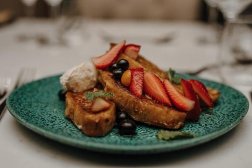 a green plate of food with fruit on it at The Hawthorn Boutique Hotel in George