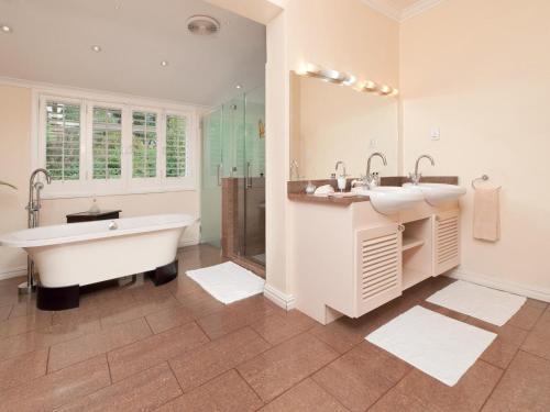 y baño con 2 lavabos, bañera y ducha. en Bellavista, en Gansbaai