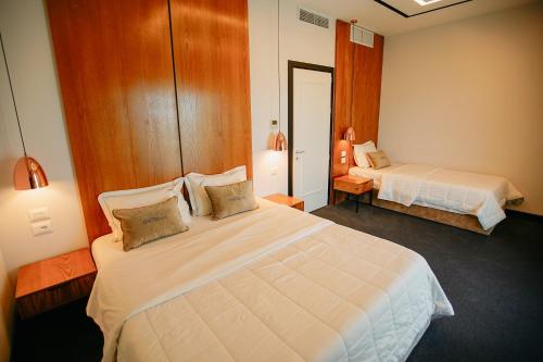 a hotel room with two beds and a mirror at Hotel Delta Premium in Durrës