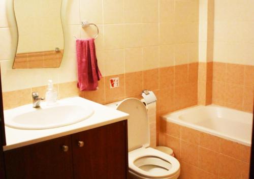 een badkamer met een wastafel, een toilet en een bad bij Marina Apartment 4 in Larnaka