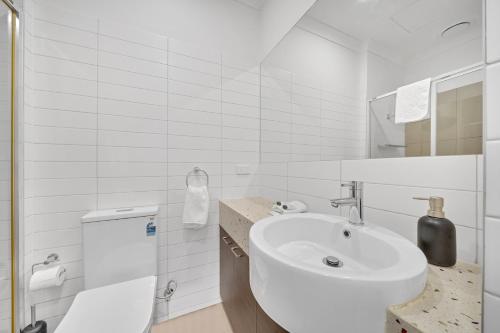 Baño blanco con lavabo y aseo en Grosvenor 3121 Richmond, en Melbourne