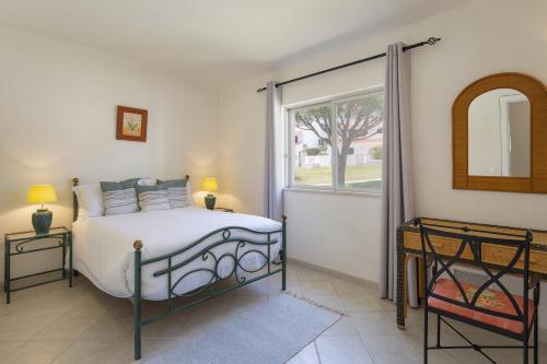 sypialnia z łóżkiem i dużym oknem w obiekcie Villa Flamingo w mieście Vale do Lobo