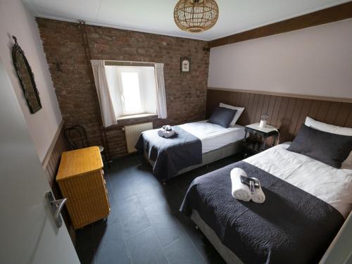 een hotelkamer met 2 bedden en een raam bij Op adem komen op de mooiste plek in het heuvelland-De Boswachter in Vijlen