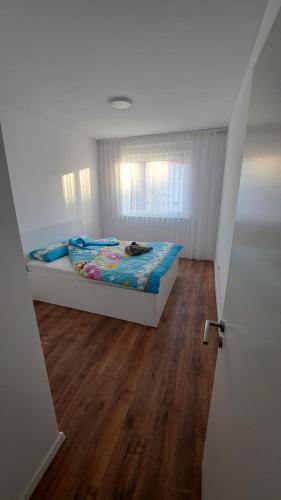 1 dormitorio con 1 cama y suelo de madera en Street C apartment nr 2, en Pristina