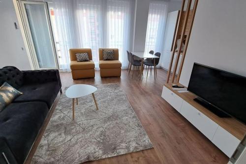 a living room with a couch and a flat screen tv at Street C apartment nr 2 in Pristina