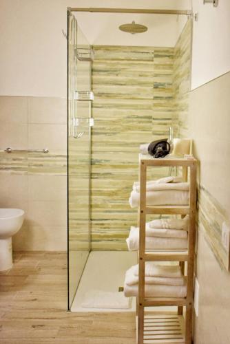 a bathroom with a glass shower and a stack of towels at Sale Hotel in Posada