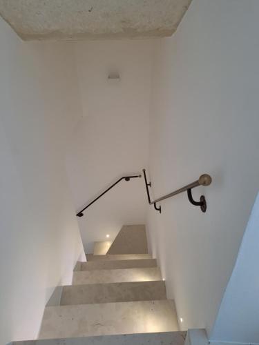 a staircase in a house with a metal hand rail at Palazzo AD 1892 - SUITES & SPA in Ostuni