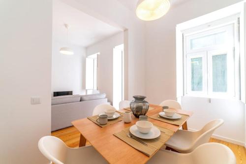a dining room with a wooden table and white chairs at Amaro I - Boutique 2 bed apartment in Alcantara in Lisbon