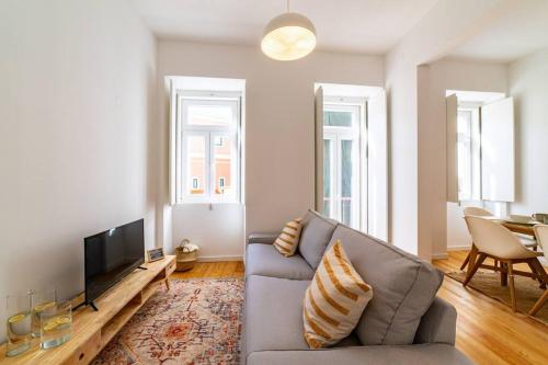 a living room with a couch and a television at Amaro I - Boutique 2 bed apartment in Alcantara in Lisbon