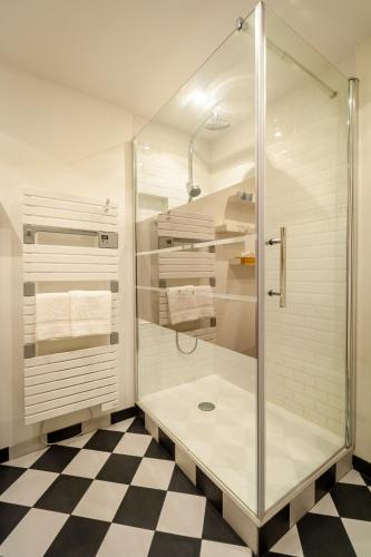 La salle de bains est pourvue d'une douche en verre et d'un sol en damier. dans l'établissement La Résidence I Cœur vieille ville, à Annecy