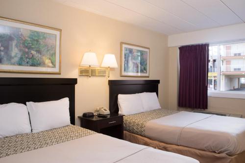a hotel room with two beds and a phone at Atlantic Motor Inn Near Boardwalk in Atlantic City