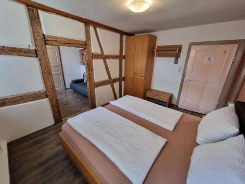 een slaapkamer met 2 bedden en een deur naar een kamer bij Gasthof Goldener Stern in Iphofen