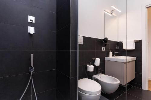 La salle de bains est pourvue de toilettes, d'un lavabo et d'un miroir. dans l'établissement Scipioni Holiday House, à Rome