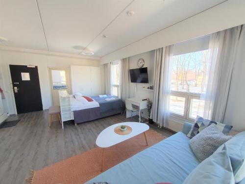 a living room with a blue couch and a bed at City Apartment 302 in Loviisa