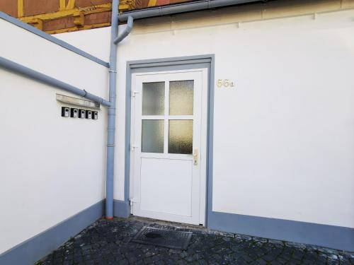 a white door in a white building with a window at Musashi Apartment 2 in Weimar