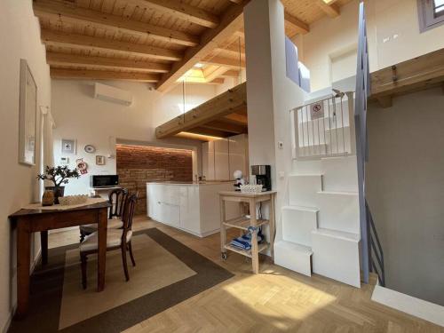 uma cozinha e sala de jantar com uma mesa e uma escada em La Piccola Casa al Lago - Intera casa con 3 camere e 2 box em Salò