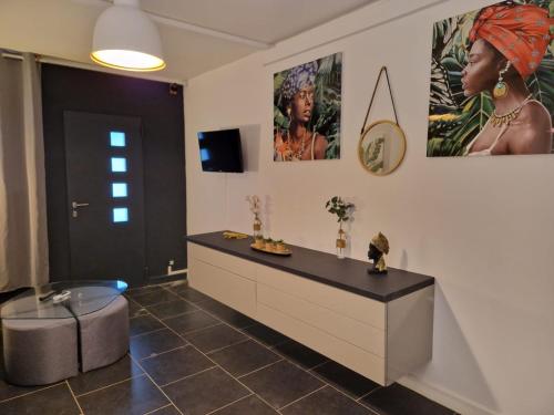 um quarto com uma cómoda e cartazes na parede em Appart Damazonie T3 Idéalement situé em Montjoly