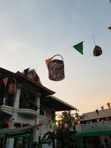 a building with flags and clotheslines in front of a house at Bloom Garden Bed & Breakfast in Siem Reap