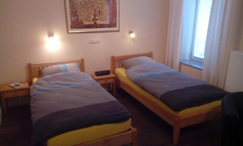 two beds in a small room with two lamps at DARZ GästeZimmer in Hamburg