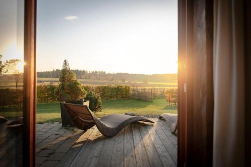 a porch with a chair and a view of a yard at Widmann's Löwen in Königsbronn