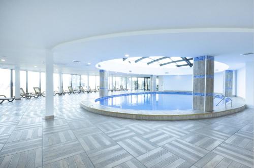 un grand hall avec une piscine au milieu d'un bâtiment dans l'établissement Sky Tower Hotel, à Batoumi