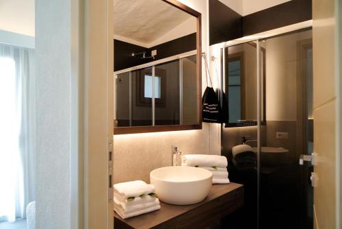 a bathroom with a sink and a mirror at AMASEA Resort in San Teodoro