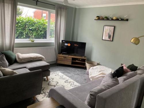 sala de estar con 2 sofás y TV en Modern cosy home sleeps 6 with parking nr Preston en Leyland