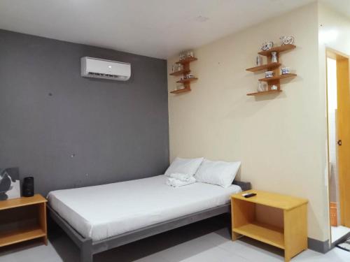 Un pequeño dormitorio con una cama blanca y estanterías en Baby Lee's Tourist Inn, en Corón