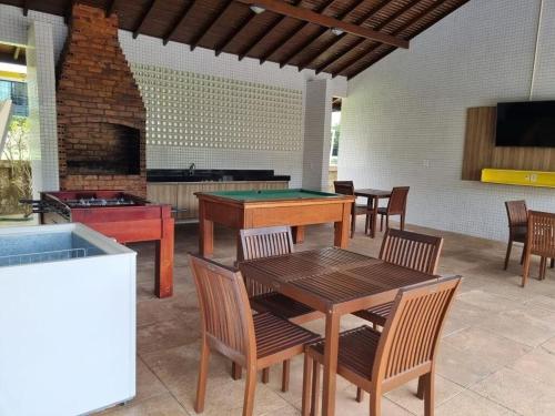 a patio with a pool table and a fireplace at Casa em Condomínio Fechado com Sauna e Piscina in Salinópolis