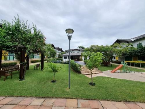 a park with two trees and a light pole at Casa em Condomínio Fechado com Sauna e Piscina in Salinópolis