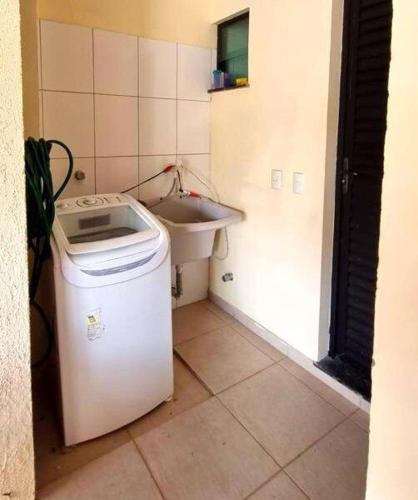 a small bathroom with a sink and a washing machine at Casa em Condomínio Fechado com Sauna e Piscina in Salinópolis