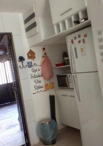 a kitchen with a refrigerator and a microwave at Casa em Condomínio Fechado com Sauna e Piscina in Salinópolis